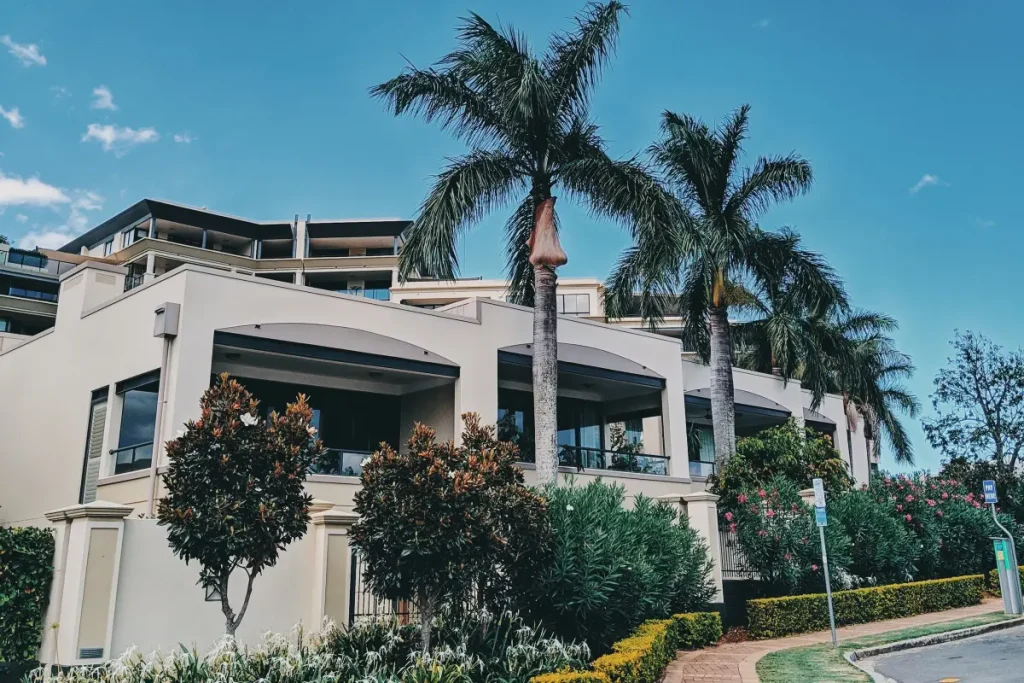 Brisbane house with palm trees and garden beds around the building
