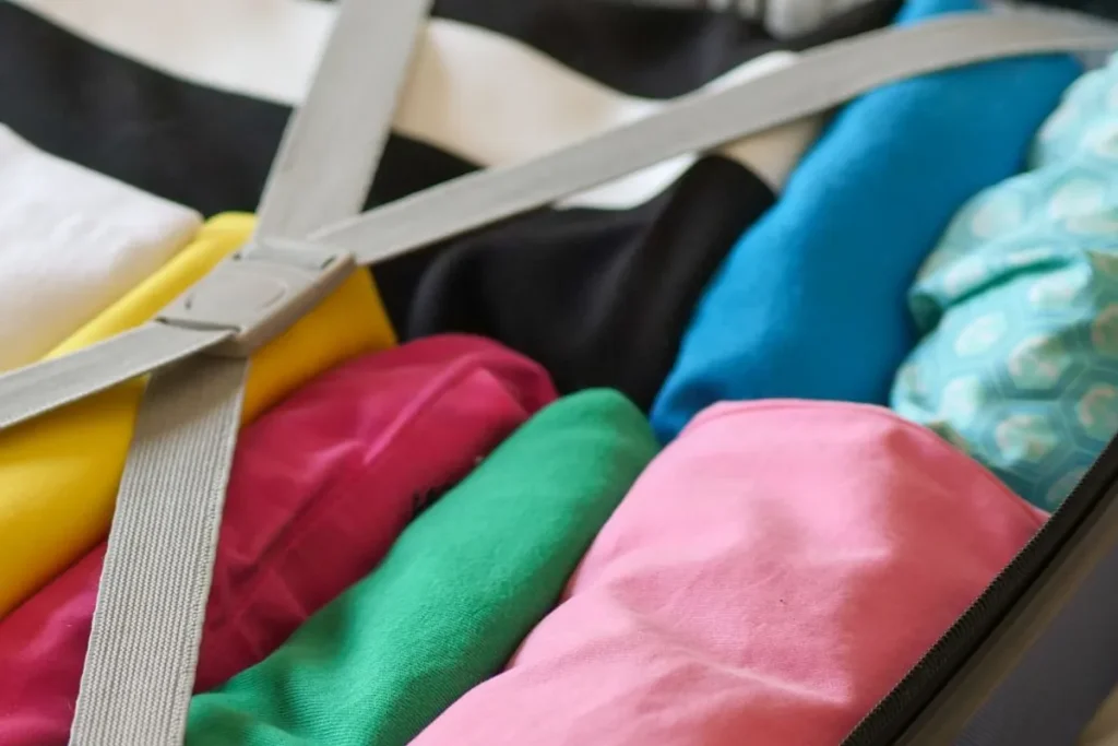 Rolled clothes held by straps inside an open suitcase
